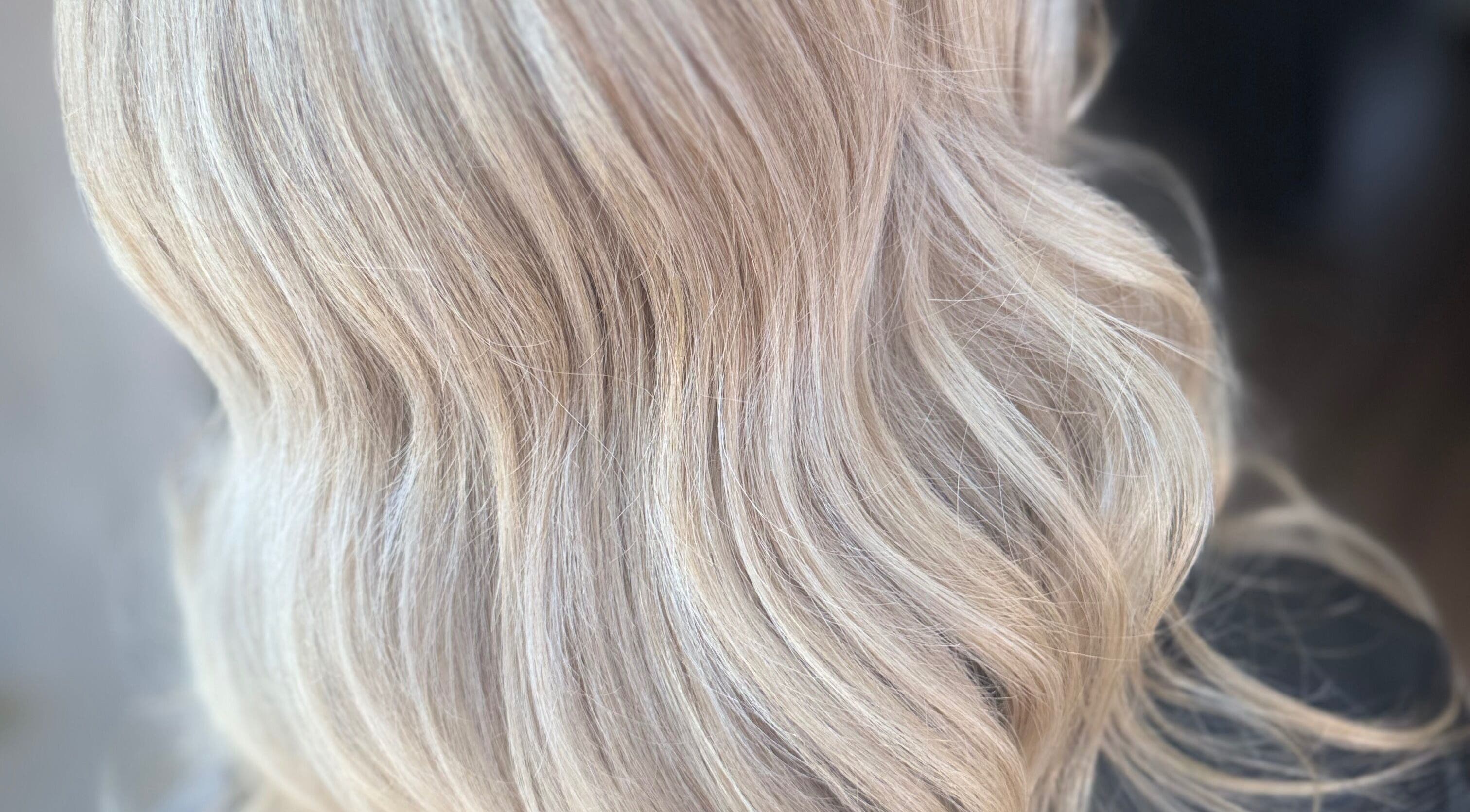 Flowing blonde hair styled in waves at Seventeen Shades, Ystrad Mynach, Wales, GB.