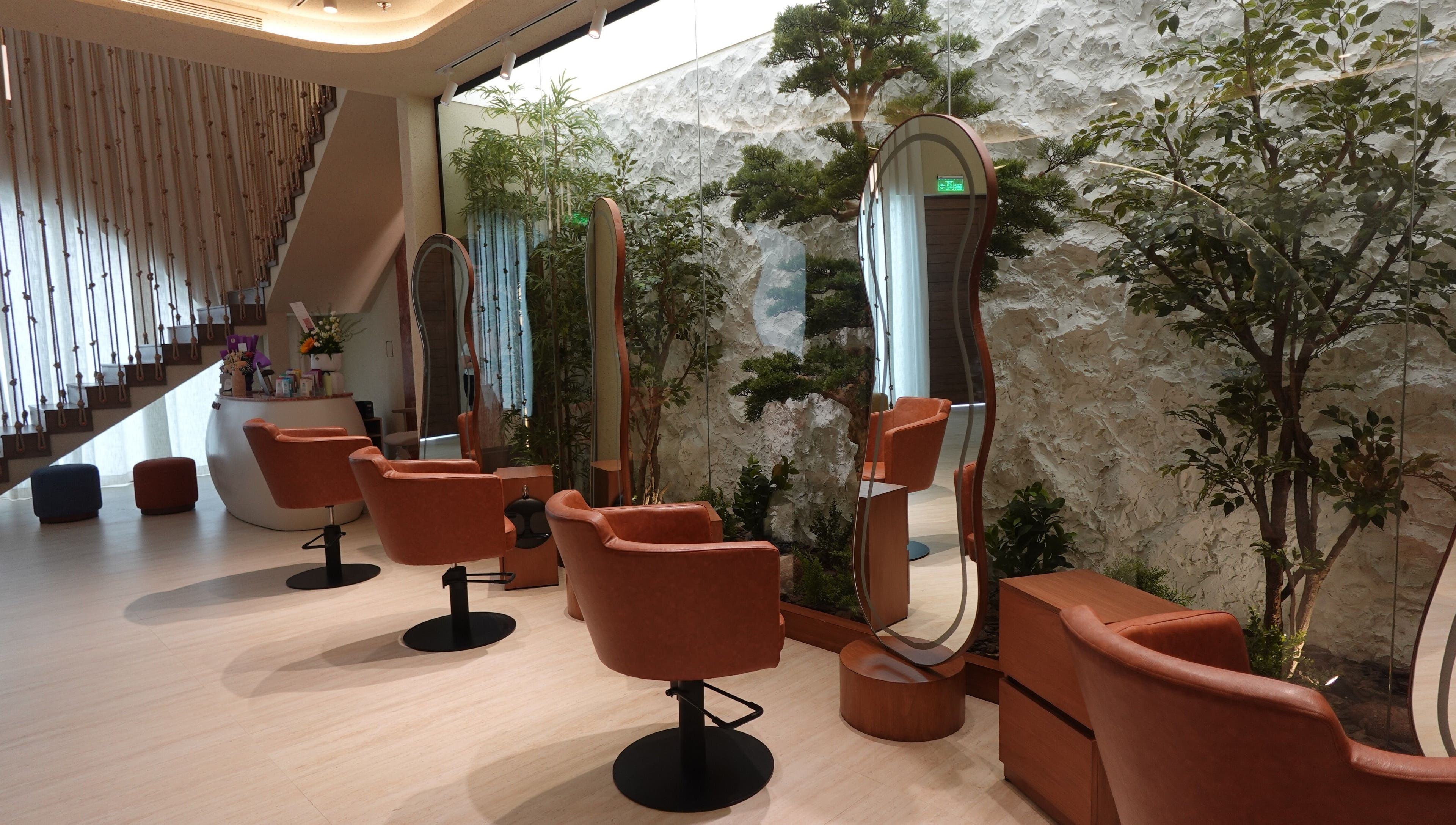 Elegant interiors of Beautiholic Salon in Al Khobar, Eastern Province, SA, featuring stylish chairs and lush greenery.