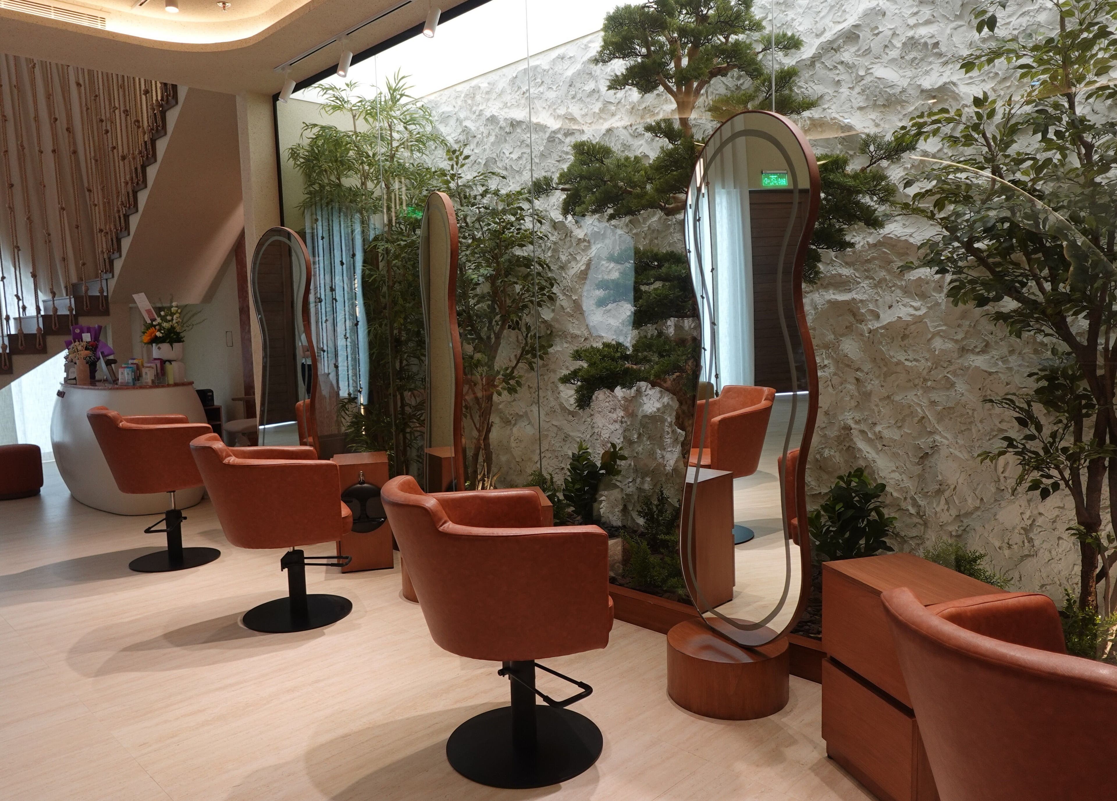 Elegant interiors of Beautiholic Salon in Al Khobar, Eastern Province, SA, featuring stylish chairs and lush greenery.