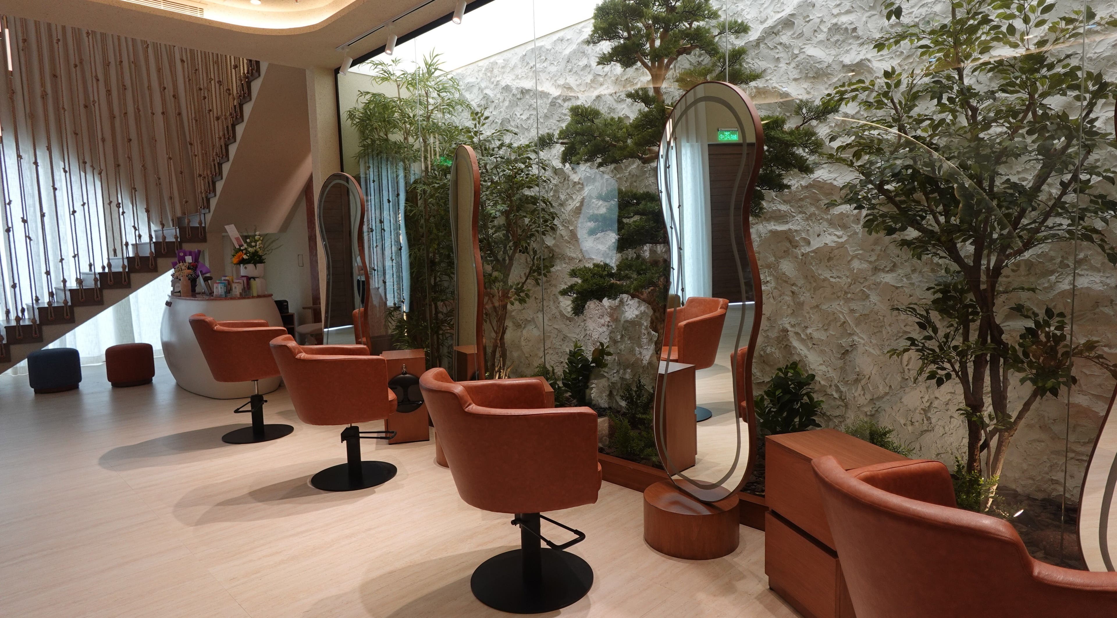 Elegant interiors of Beautiholic Salon in Al Khobar, Eastern Province, SA, featuring stylish chairs and lush greenery.