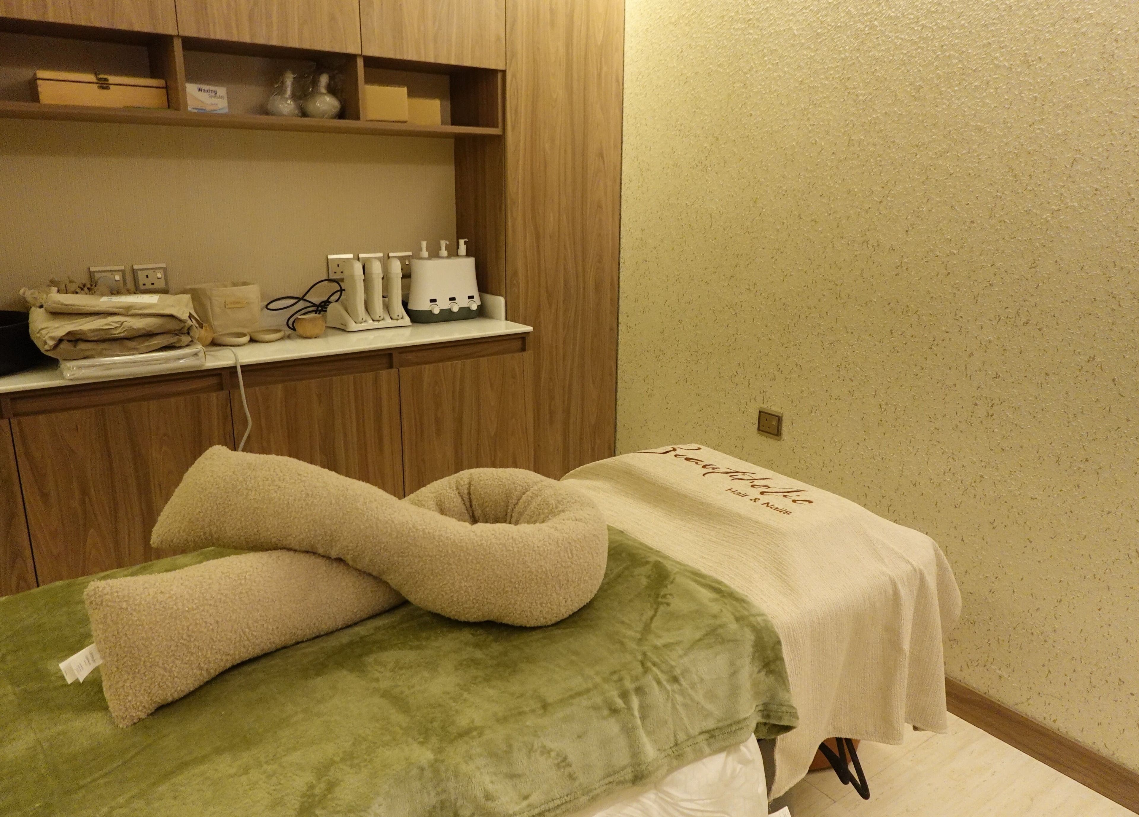 Cozy treatment room at Beautiholic salon, Al Khobar, Eastern Province, SA with plush towels and wooden cabinetry.
