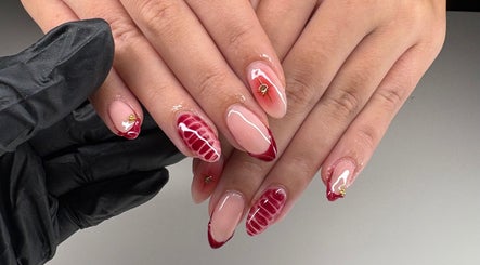 Sophisticated nail art featuring red designs by Beauty by Issy T in Redcliffe, Queensland, AU.