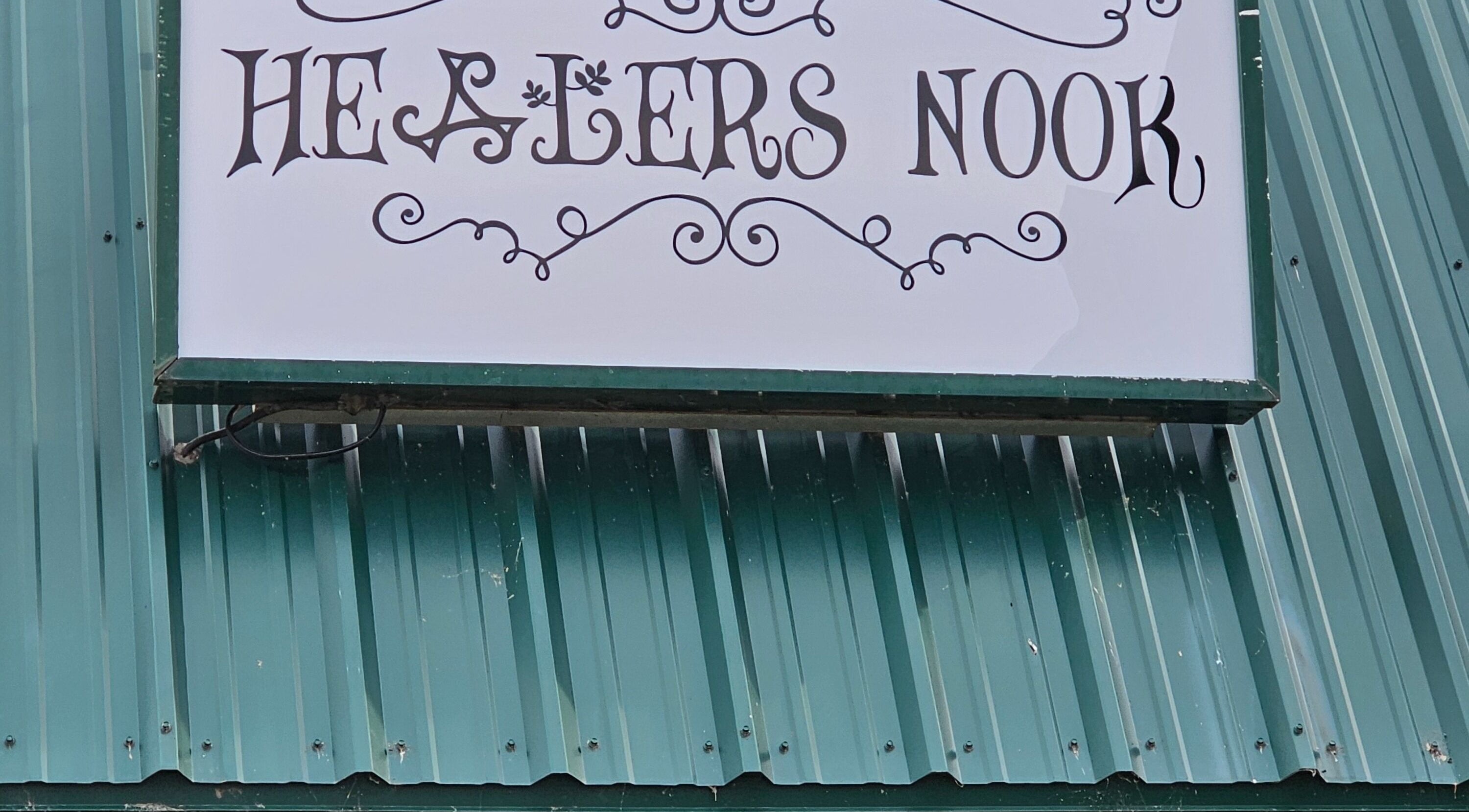 Healer's Nook Lacombe sign on green metal wall in Lacombe, Alberta, CA.