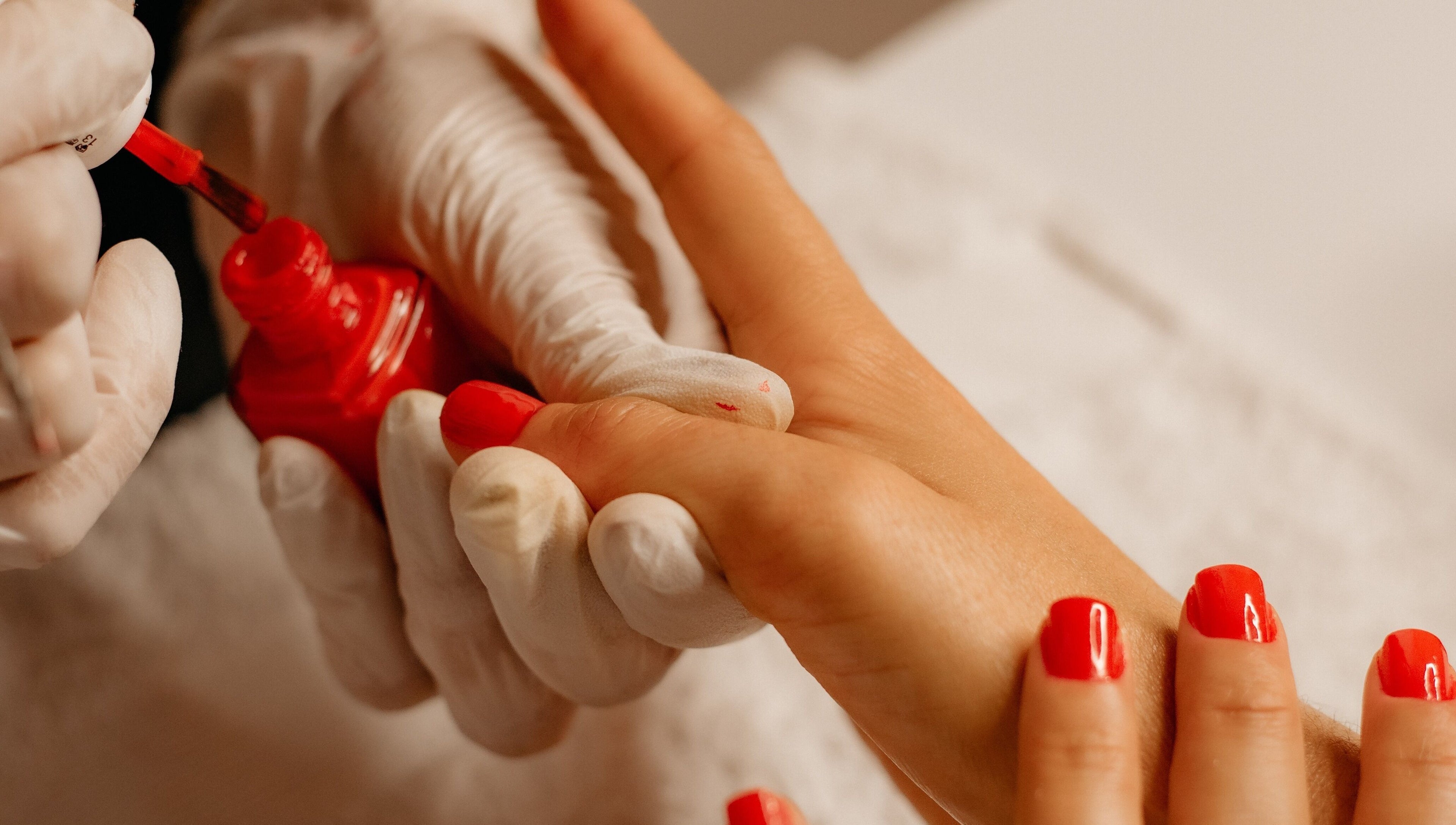 Manicure aplicando esmalte vermelho em Nails da Jhezz, Berlin, Berlin, DE.