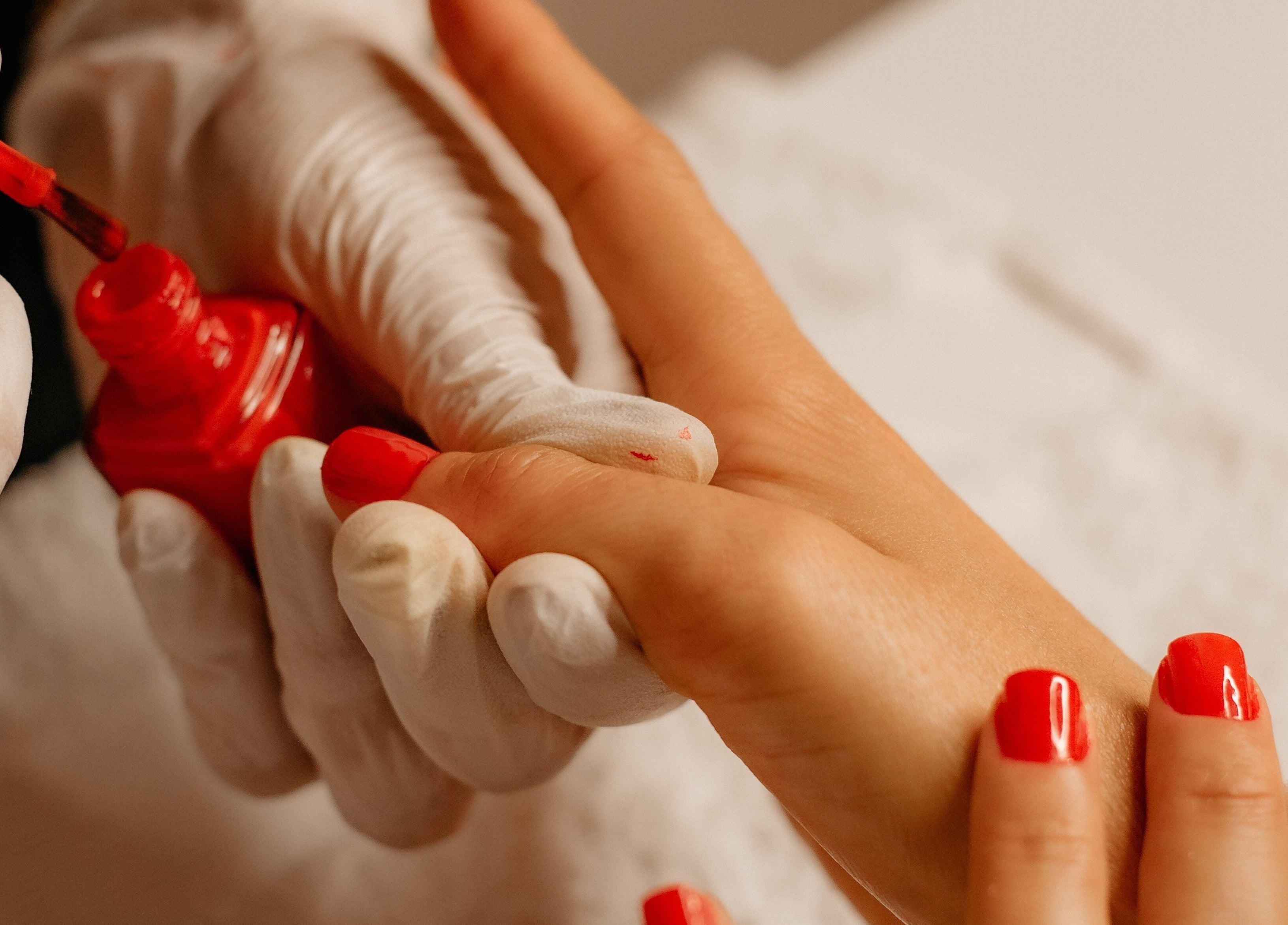 Manicure aplicando esmalte vermelho em Nails da Jhezz, Berlin, Berlin, DE.