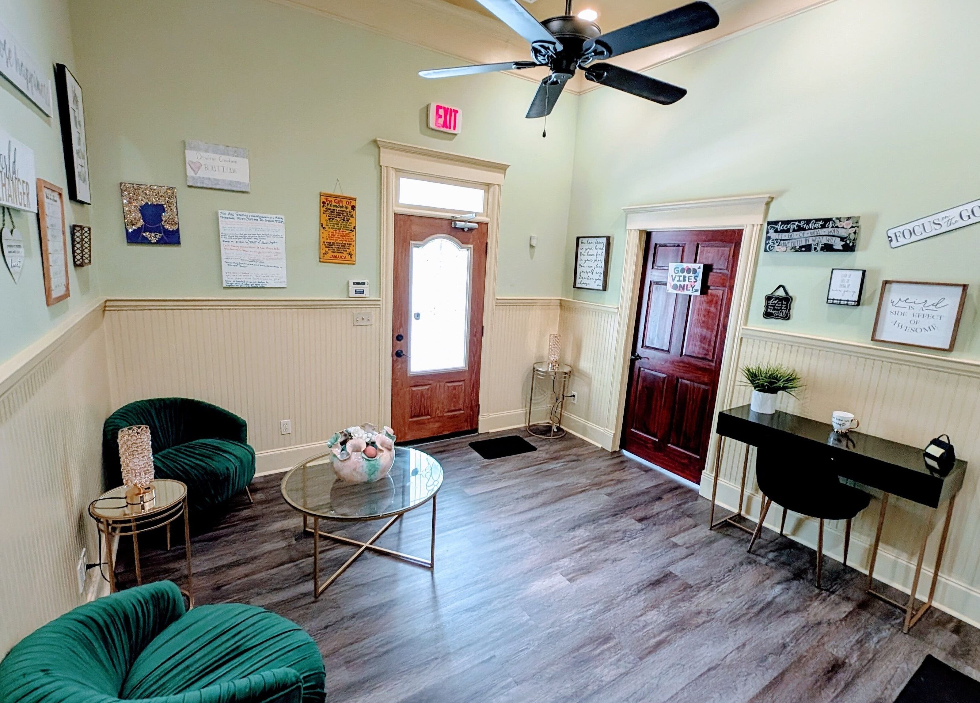 Cozy lounge area in Devine Creations, Stockbridge, Georgia, US with green chairs and wall art.