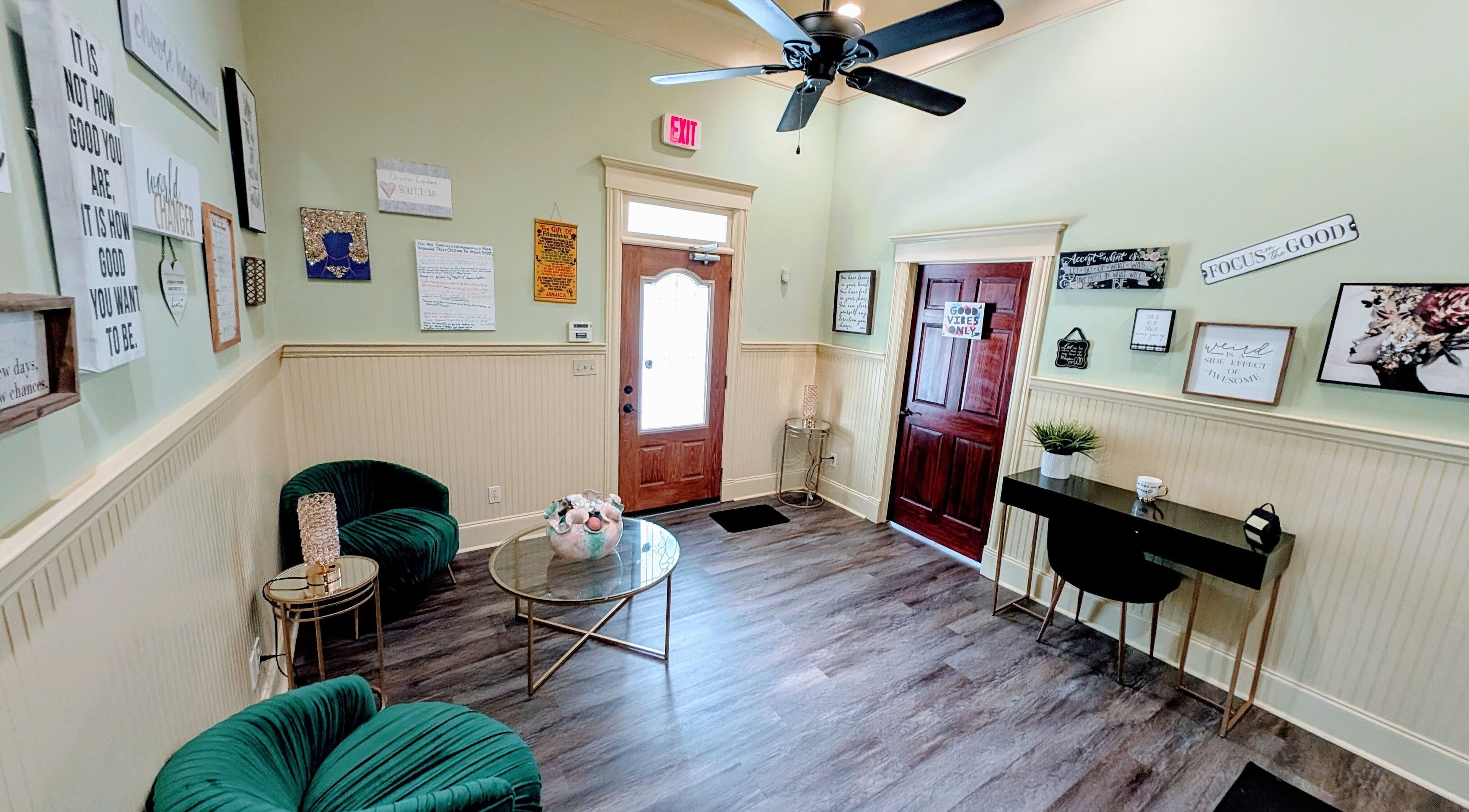 Cozy lounge area in Devine Creations, Stockbridge, Georgia, US with green chairs and wall art.