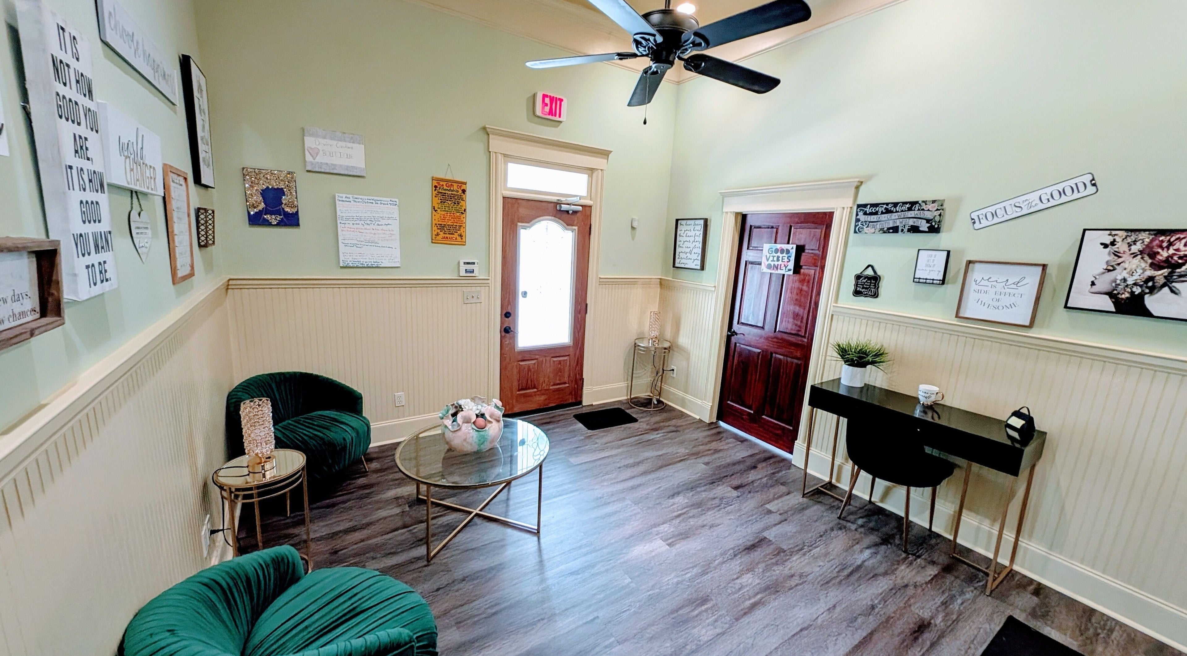 Cozy lounge area in Devine Creations, Stockbridge, Georgia, US with green chairs and wall art.
