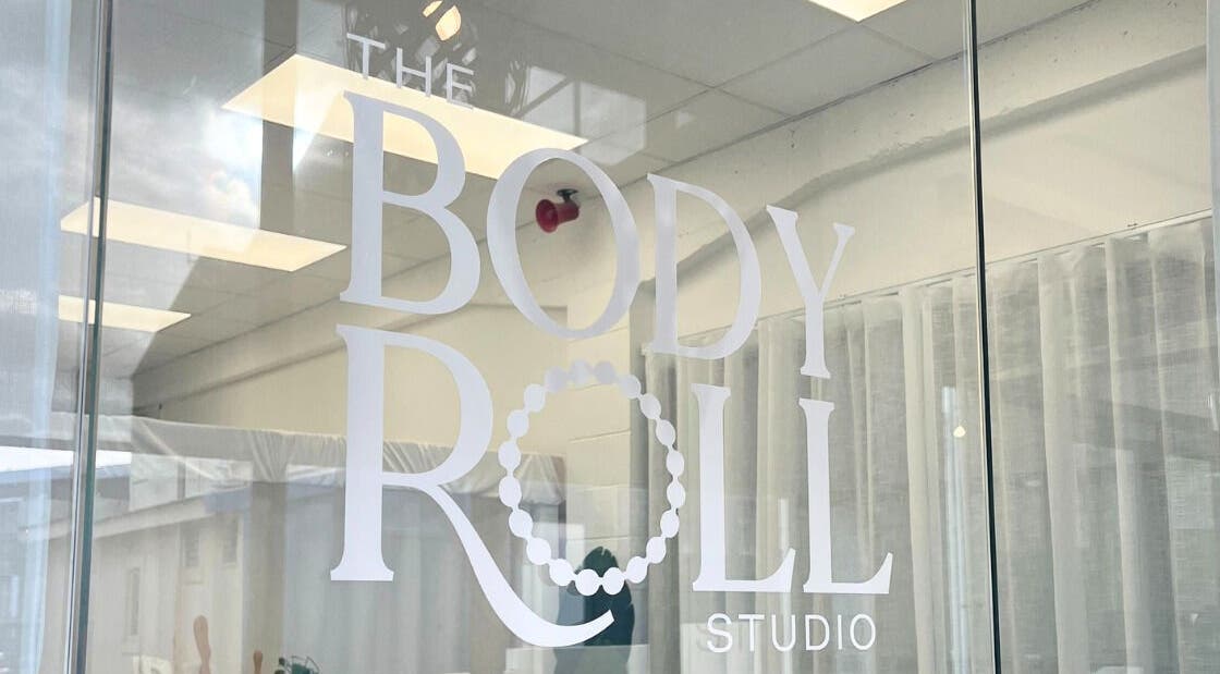 Entry to The Body Roll Studio in Auckland, Auckland, NZ with stylish glass door and minimalist decor.