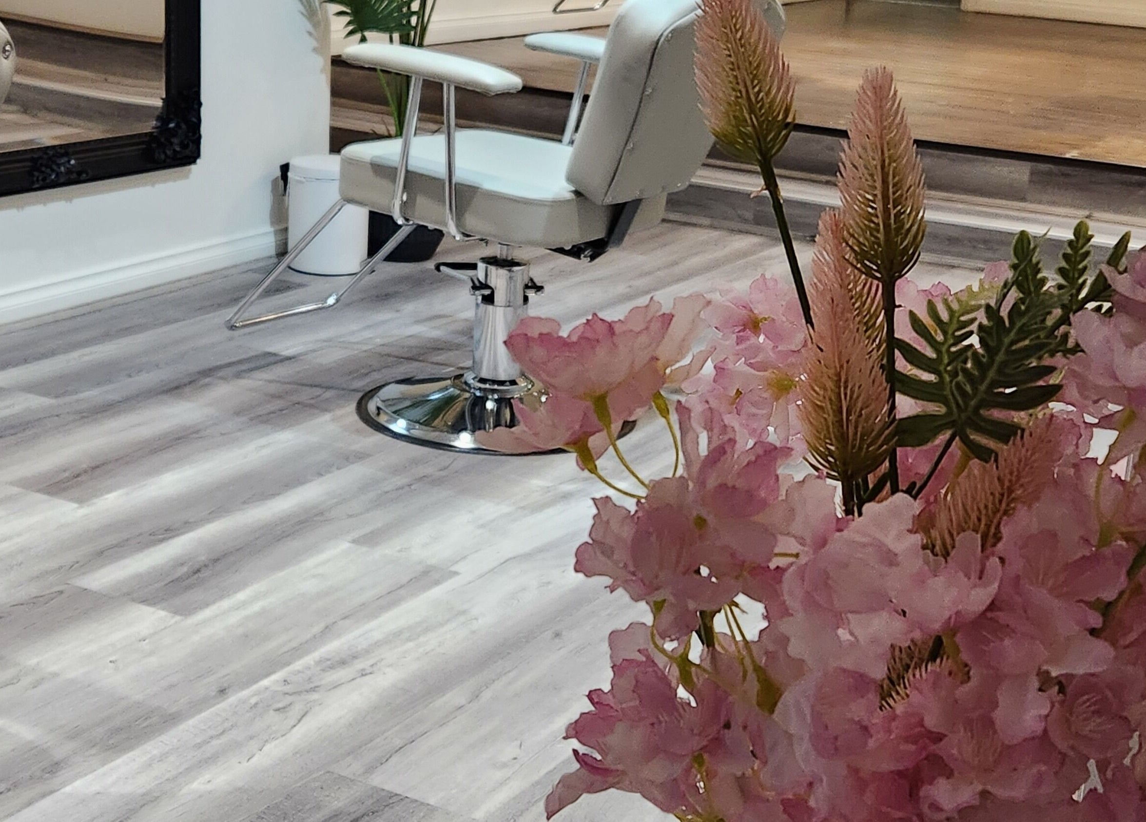 Stylish interior of Belleza Brows & Lashes in Melbourne, Victoria, AU with chic salon chair and pink florals.