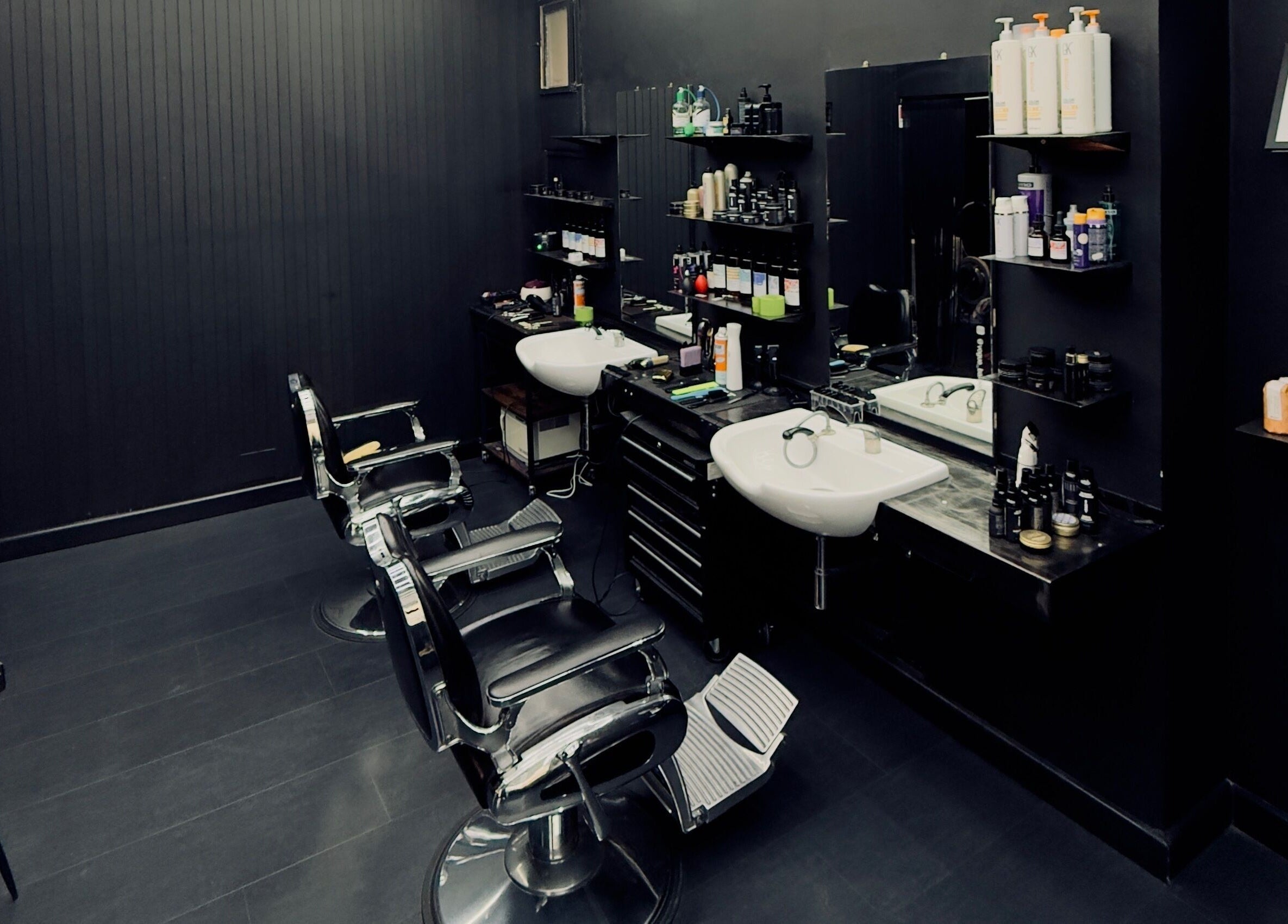 Interno moderno di Vogue Barber Shop, Arceto, Emilia-romagna, IT con poltrone eleganti e prodotti professionali.