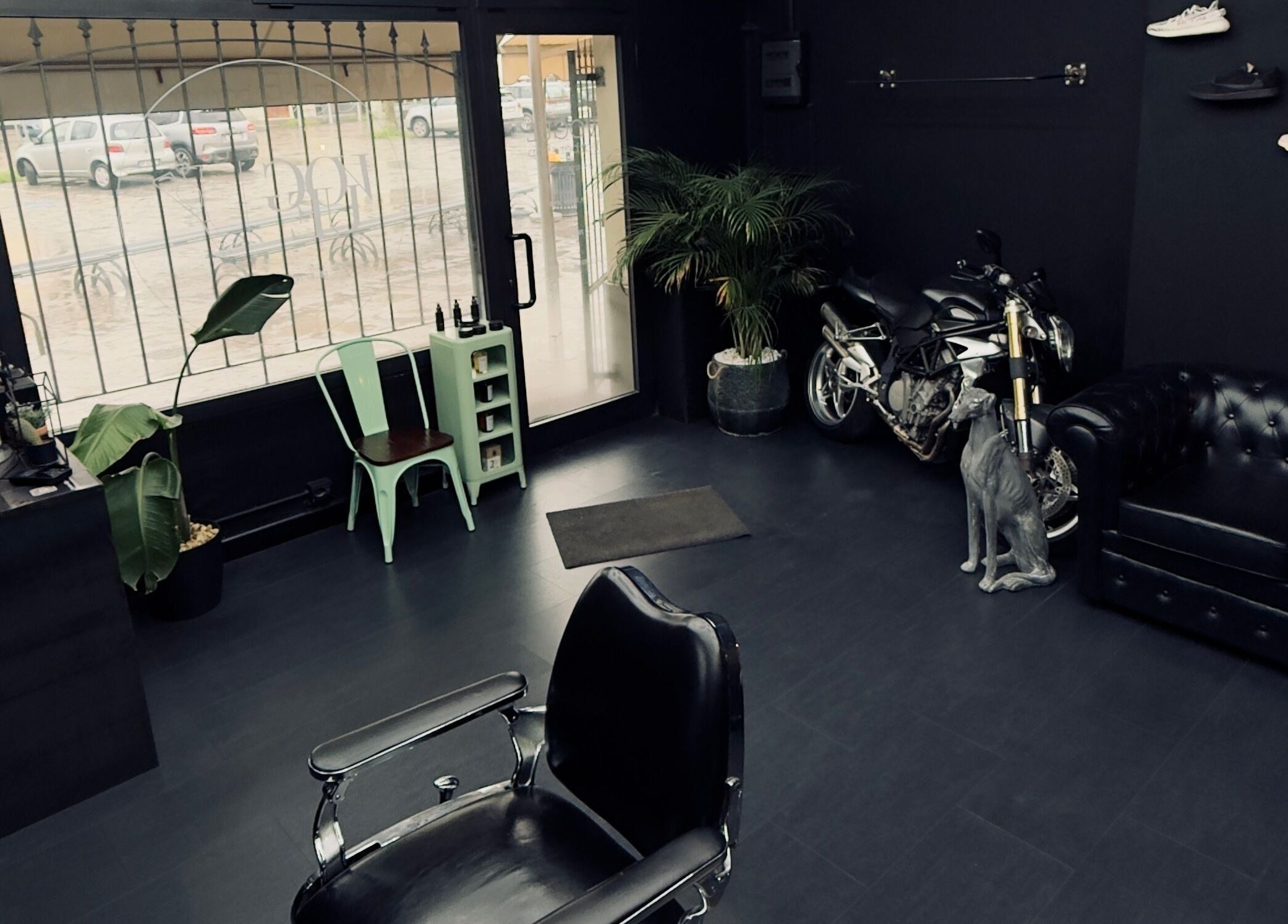 Interno di Vogue Barber Shop ad Arceto, Emilia-romagna, IT con arredamento industriale e moto stilizzata.
