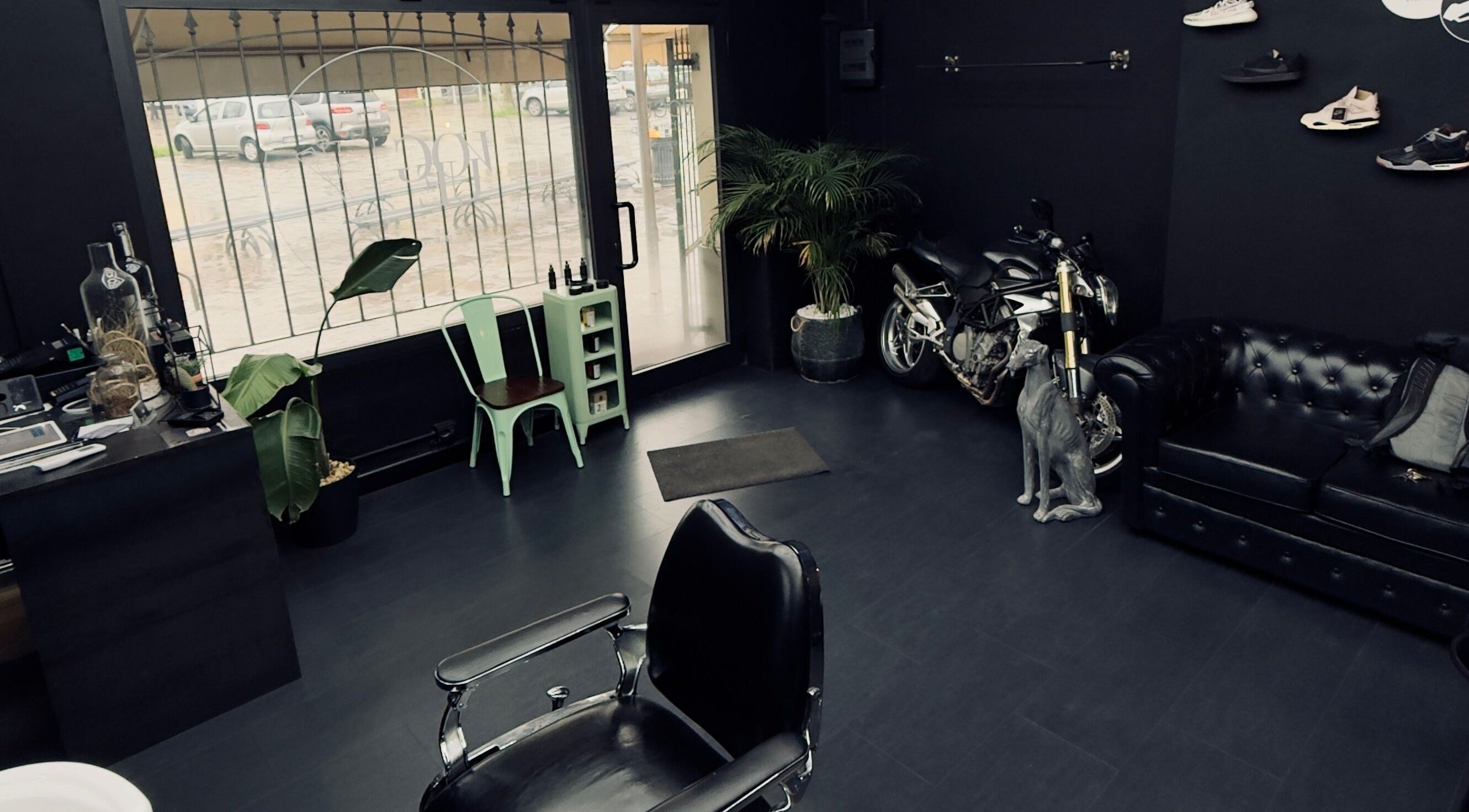 Interno di Vogue Barber Shop ad Arceto, Emilia-romagna, IT con arredamento industriale e moto stilizzata.
