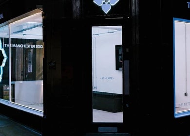 HERA X MANCHESTER SOCIAL storefront at Manchester, England, GB, featuring illuminated modern design.