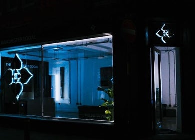 Night view of HERA X MANCHESTER SOCIAL, Manchester, England, GB, showcasing glowing neon sign.