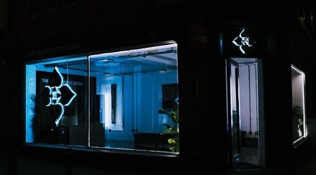 Night view of HERA X MANCHESTER SOCIAL, Manchester, England, GB, showcasing glowing neon sign.