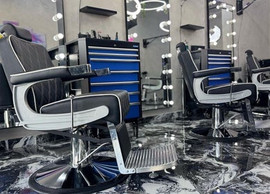 Luxury barber chairs at A Club Barbers, Dubai, Dubai, AE. Modern design with marble flooring.