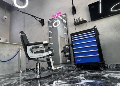 Modern barbershop interior at A Club Barbers, Dubai, Dubai, AE with sleek chair and lighted mirror.