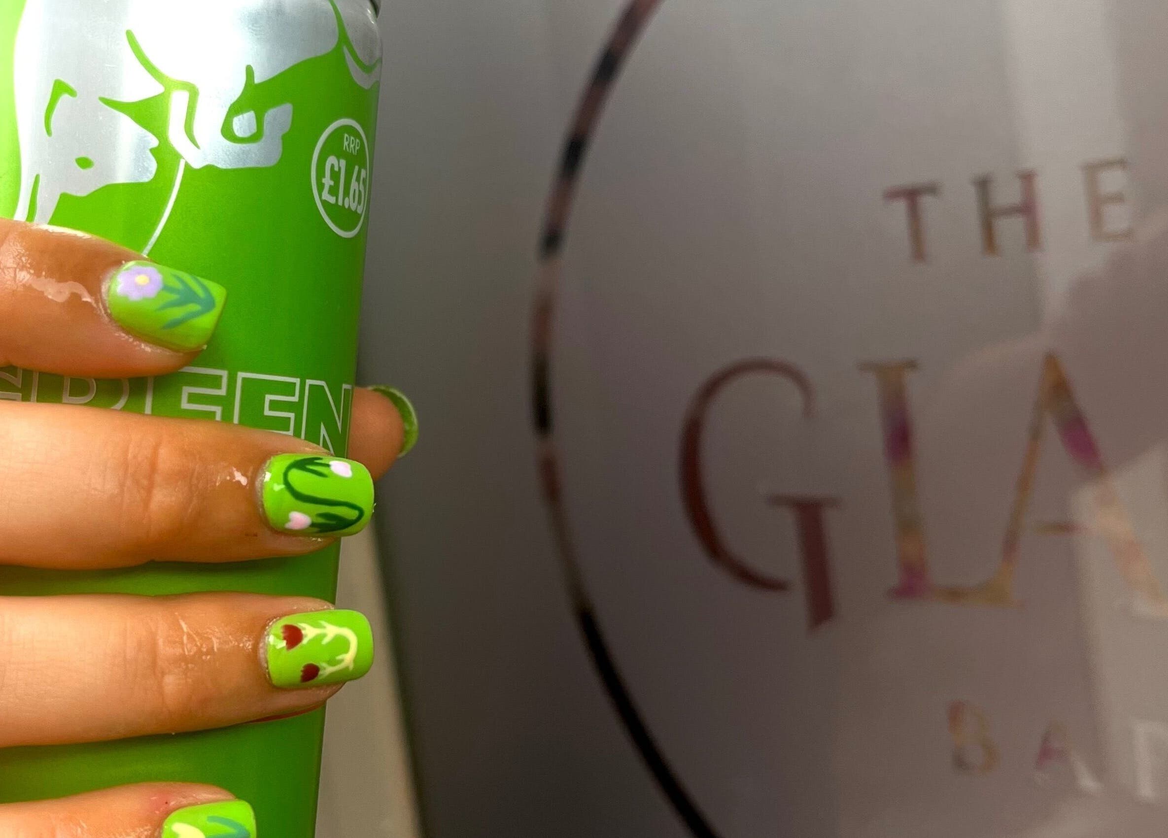 Glam Bar Ampthill showcases vibrant green nail art holding a can, Ampthill, England, GB.