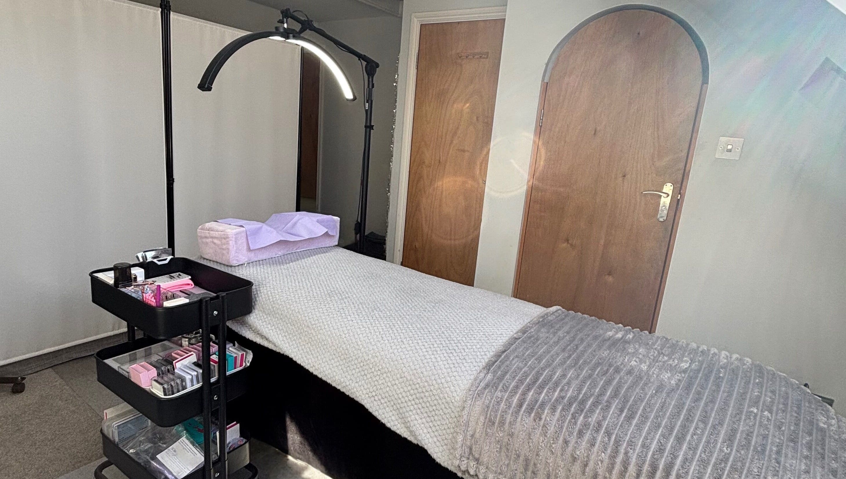 Treatment room at LA Lashes & Brows, West Wickham, England, GB with a cozy bed and beauty supplies.