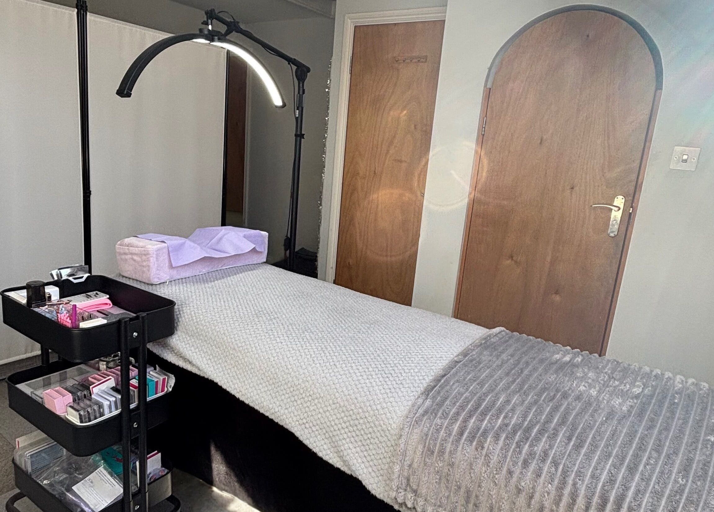 Treatment room at LA Lashes & Brows, West Wickham, England, GB with a cozy bed and beauty supplies.