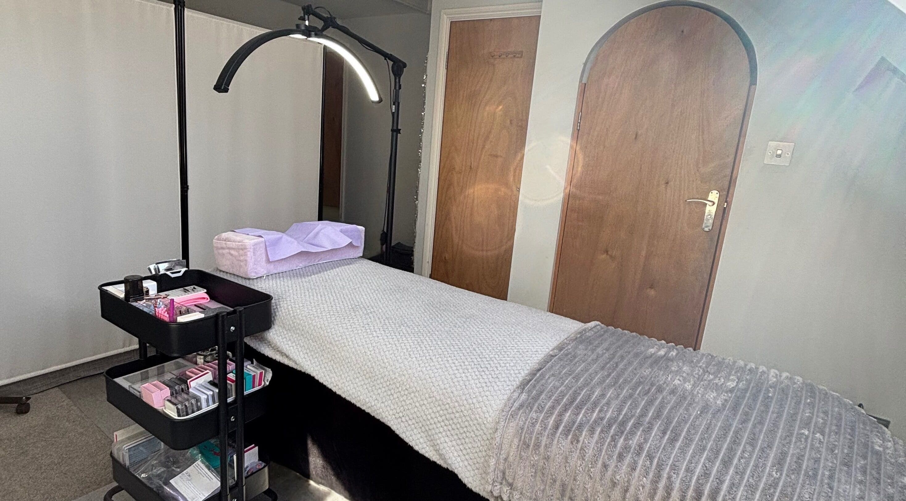 Treatment room at LA Lashes & Brows, West Wickham, England, GB with a cozy bed and beauty supplies.