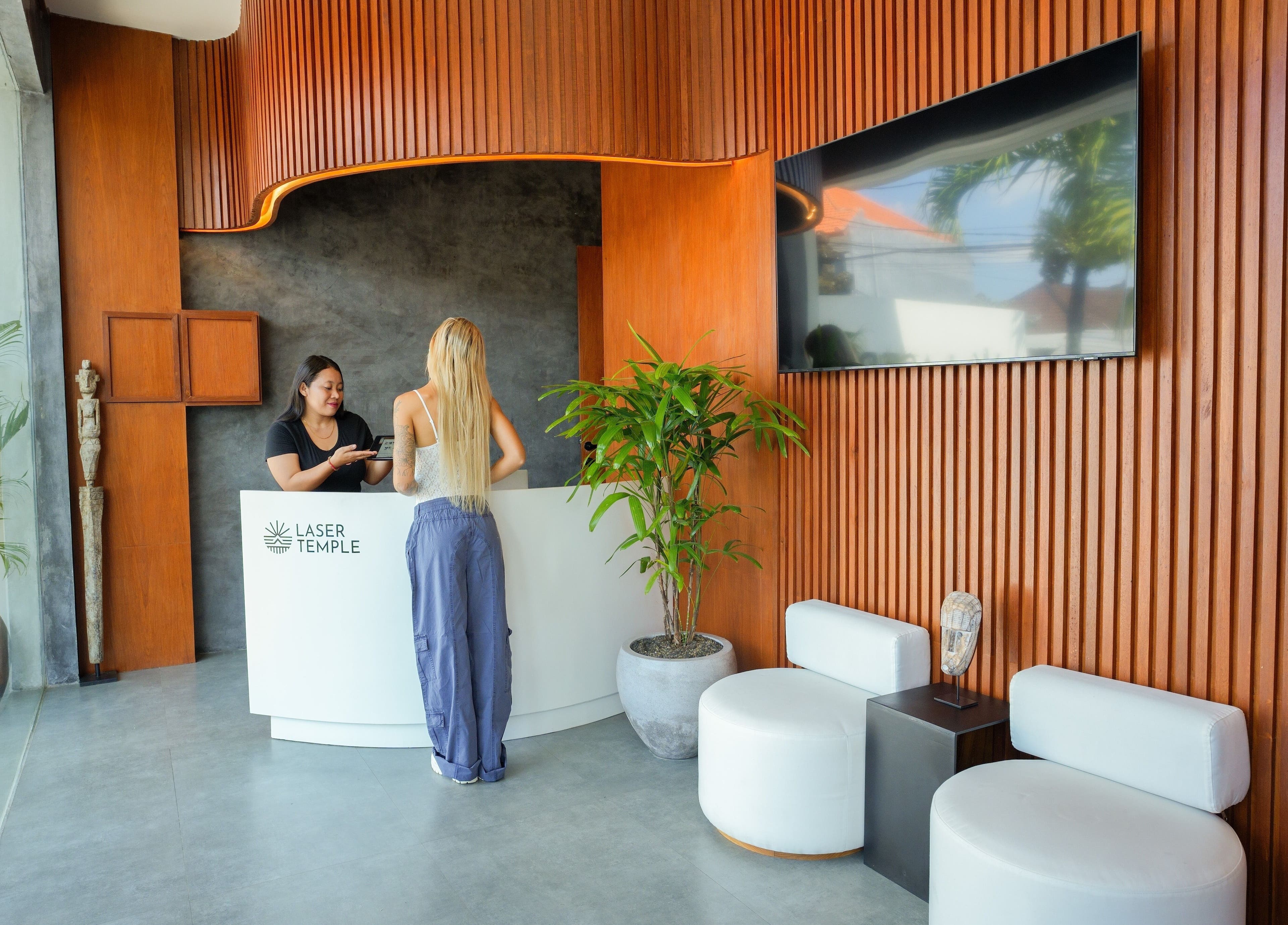 Recepción moderna en Laser Temple, Bali, Bali, ID con decoración de madera y plantas.