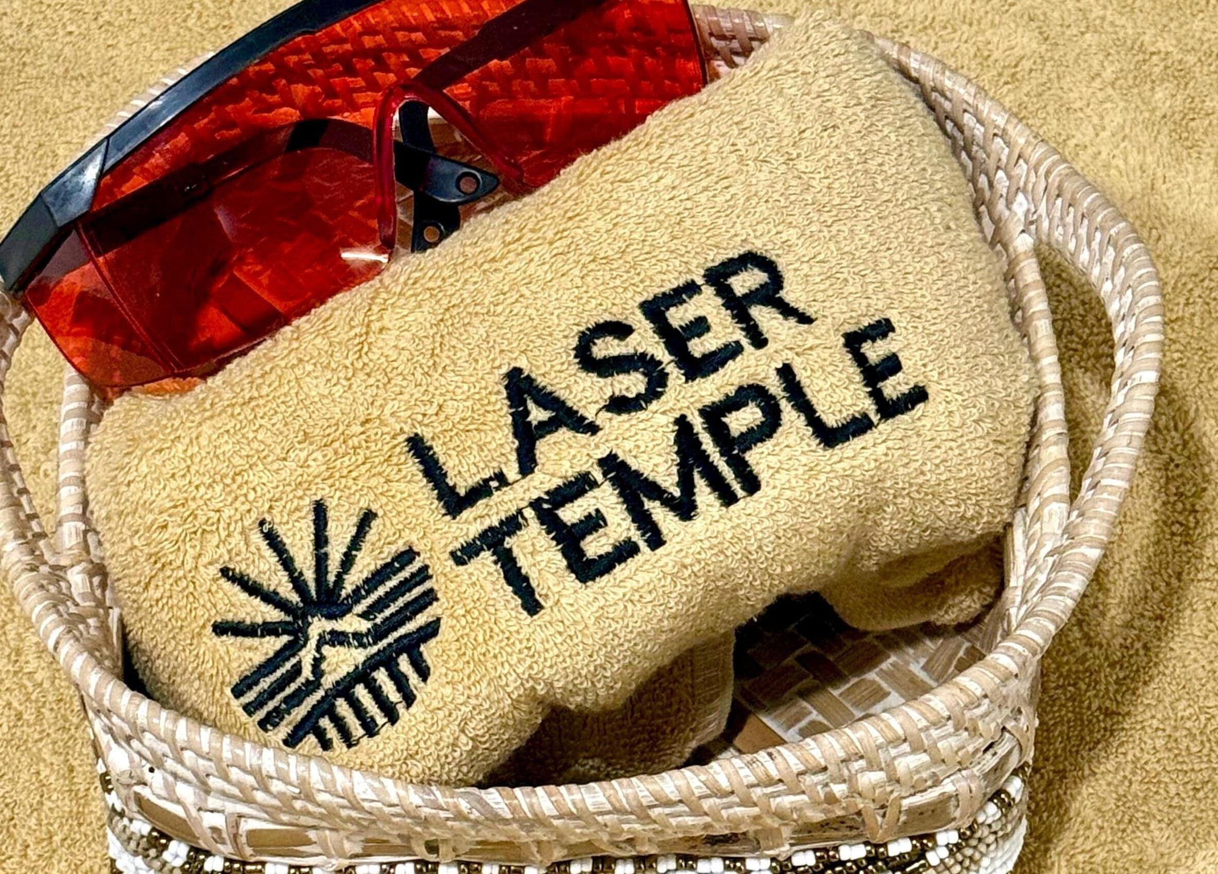 Toalla bordada de LASER TEMPLE ULUWATU en una cesta en Bali, Bali, ID, junto a gafas de protección.