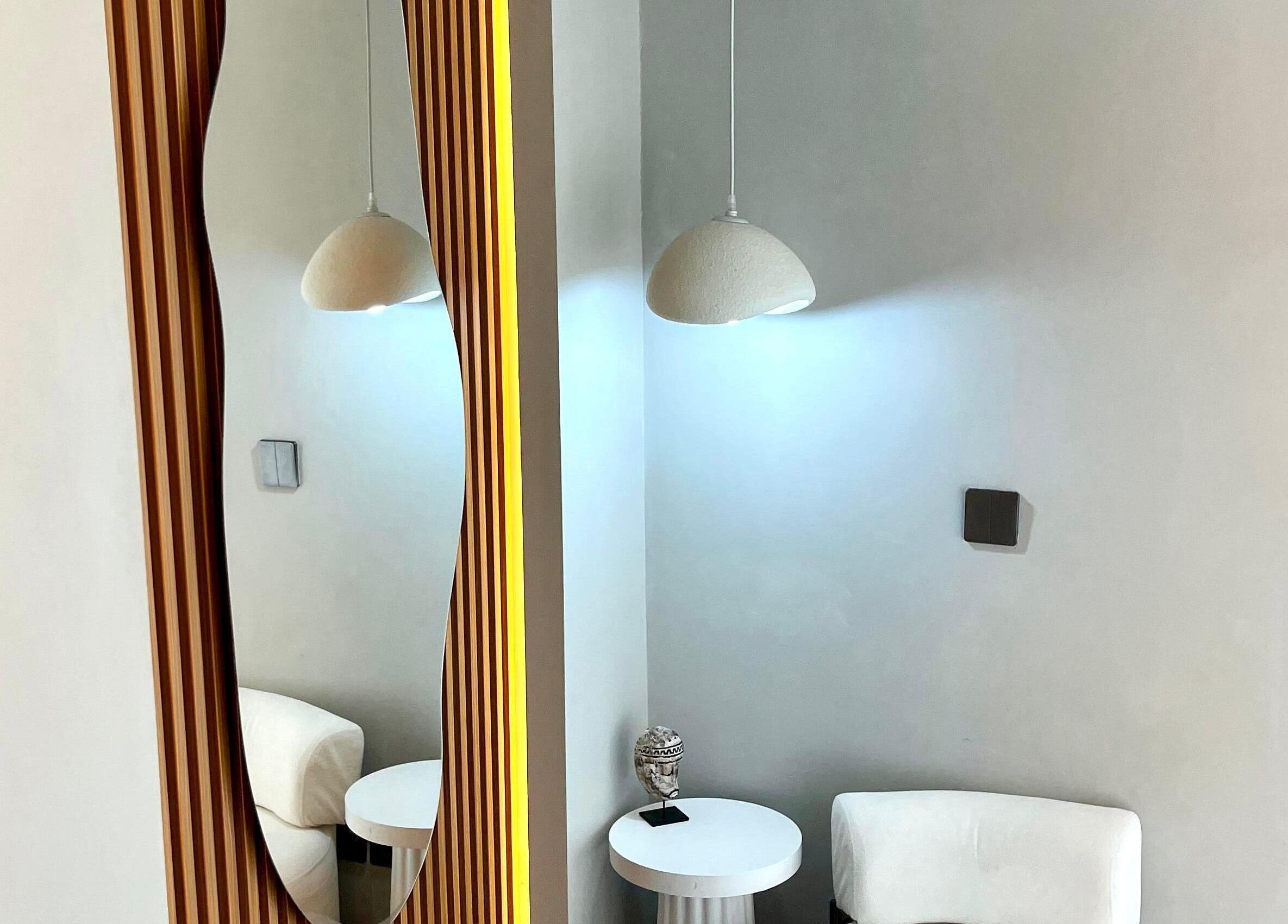 Elegante rincón con espejo y silla en LASER TEMPLE ULUWATU, Bali, Bali, ID, creando un ambiente relajante.