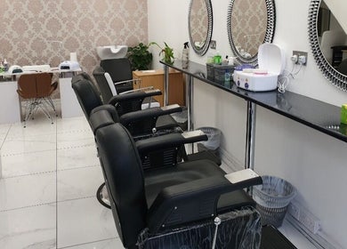 Stylish salon interior at Amrita's hair and beauty, London, England, GB with sleek chairs and modern mirrors.