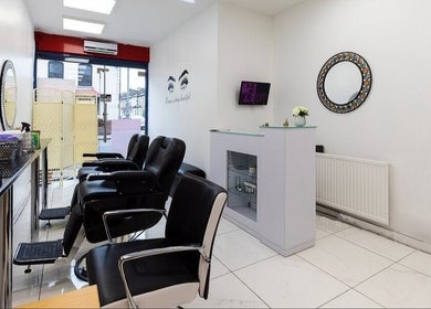 Chic salon interior at Amrita's hair and beauty in London, England, GB with sleek mirrors and stylish seating.
