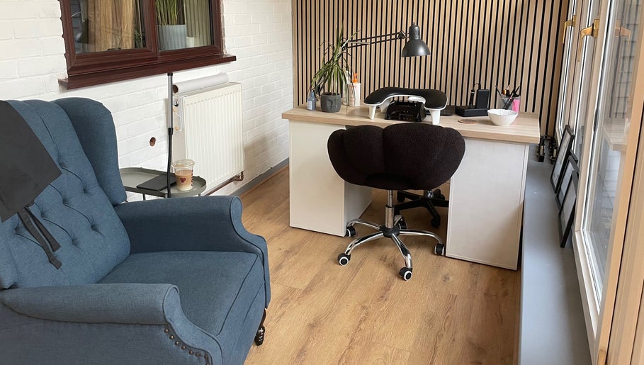 Elegant salon workspace at By Jade Emily in Newport, England, GB, featuring a plush chair and modern desk.