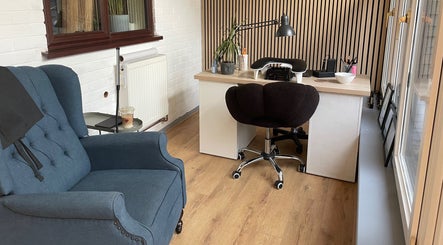 Elegant salon workspace at By Jade Emily in Newport, England, GB, featuring a plush chair and modern desk.