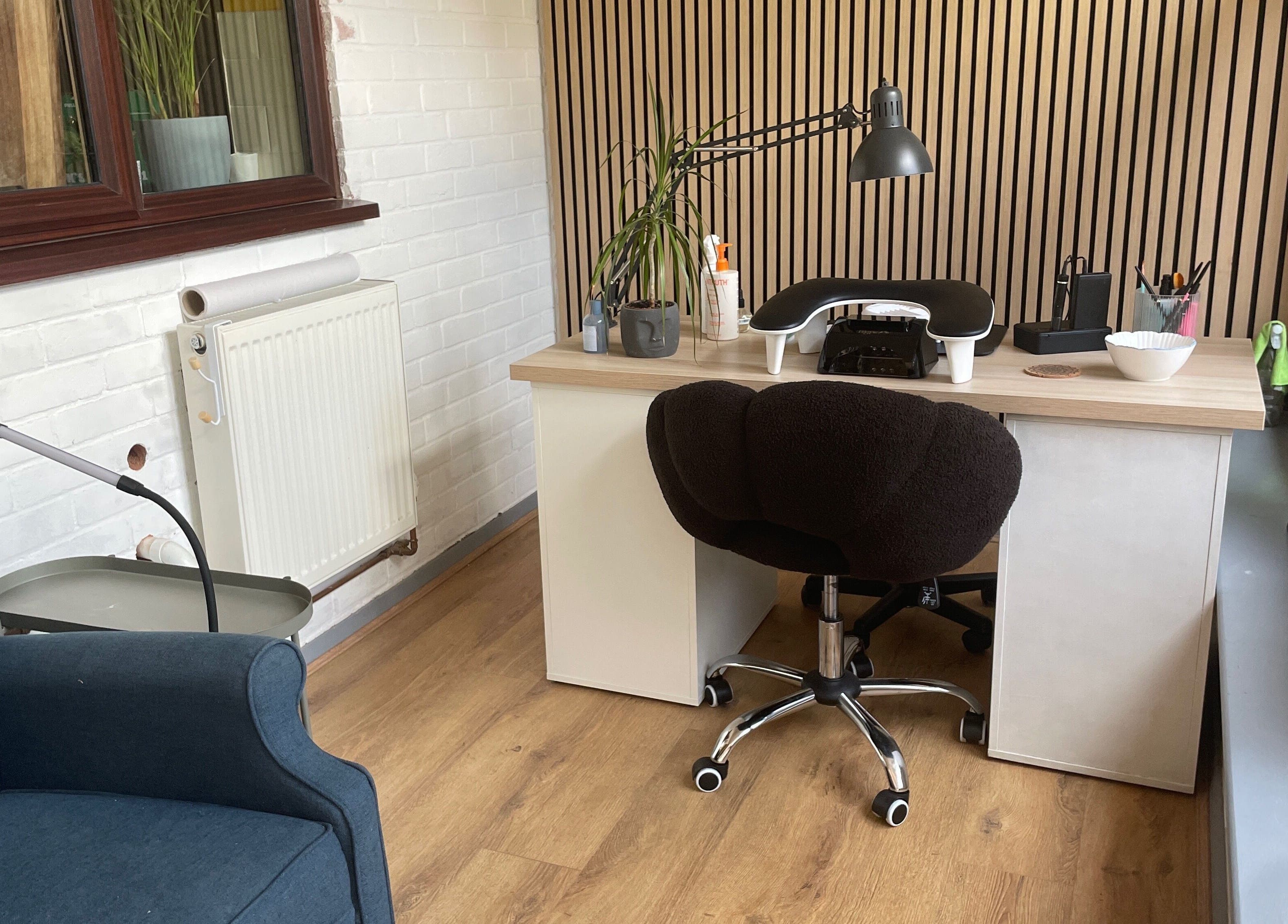 Inviting beauty desk at By Jade Emily, Newport, England, GB, featuring a cozy chair and decor.