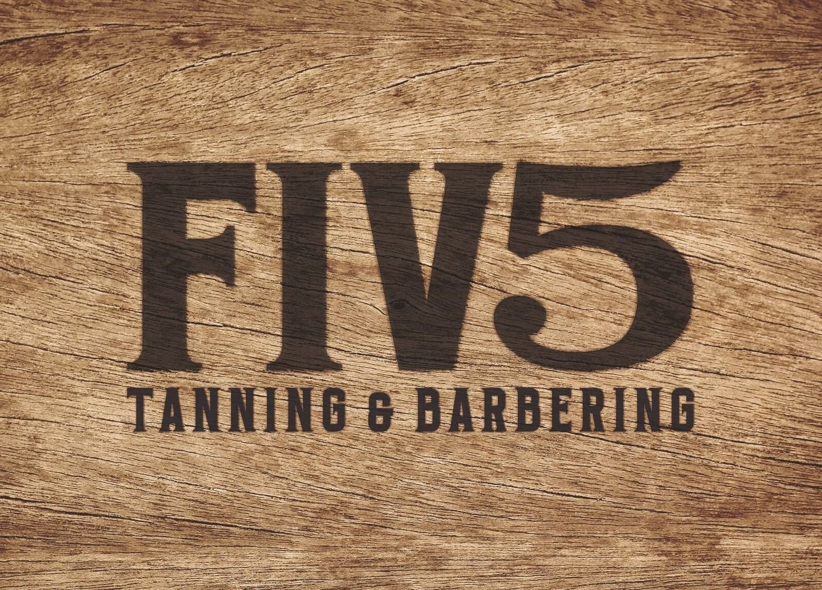 FIV5 Tanning & Barbering logo on wood texture, Sandy, England, GB.