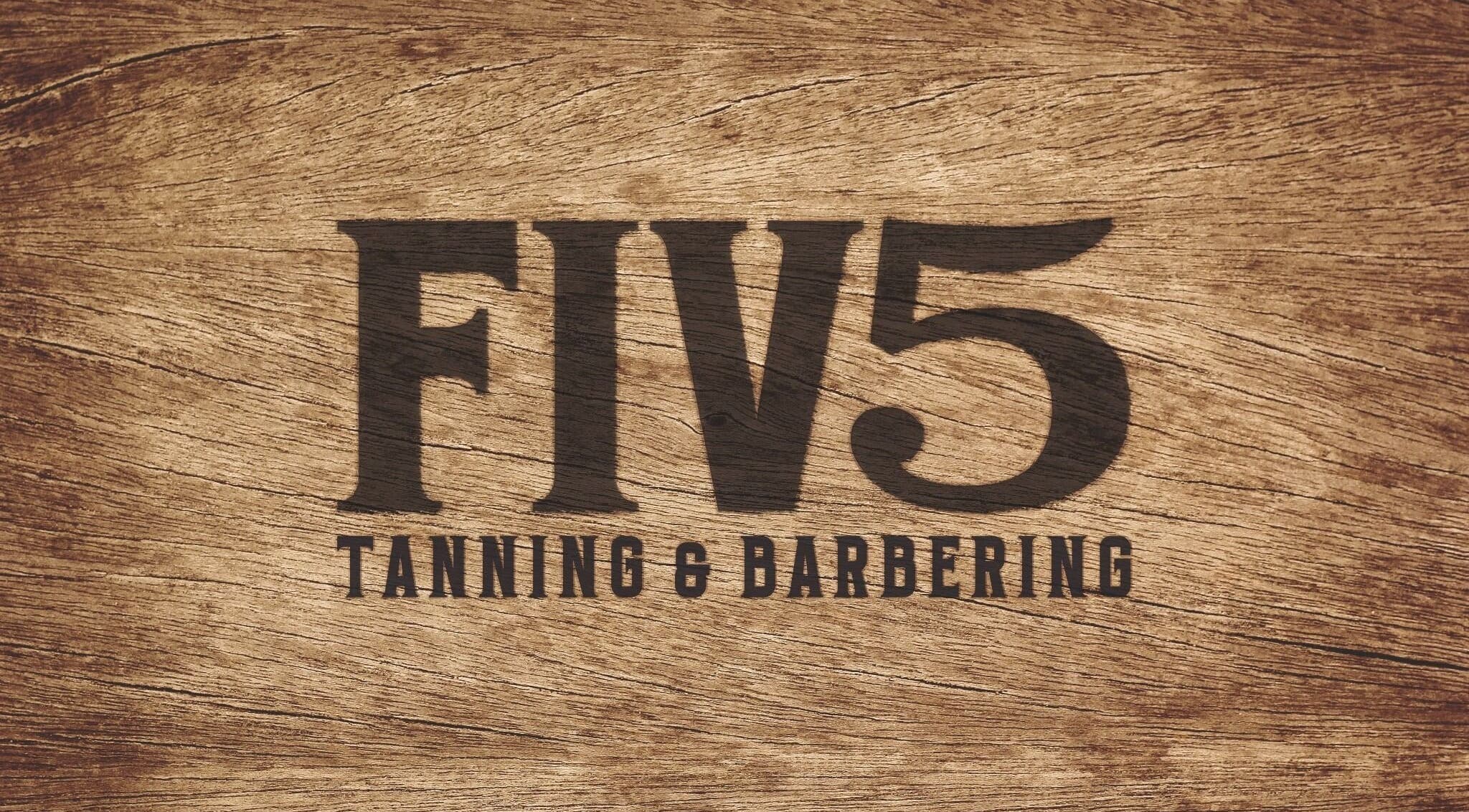 FIV5 Tanning & Barbering logo on wood texture, Sandy, England, GB.