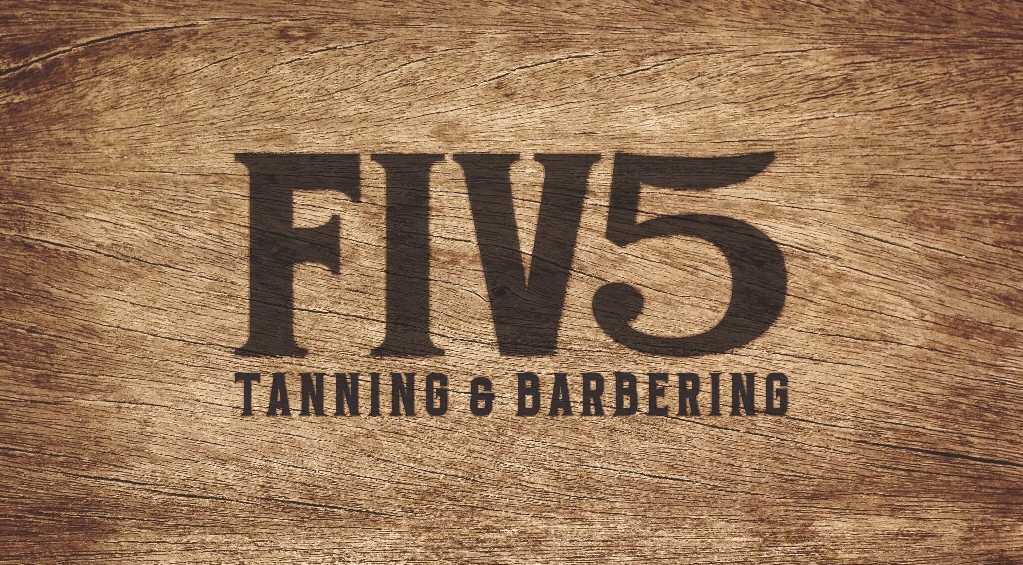 FIV5 Tanning & Barbering logo on wood texture, Sandy, England, GB.