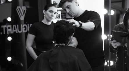 Profesional en Tonny Serrano CR estilizando cabello bajo luces cálidas, creando un ambiente de belleza.