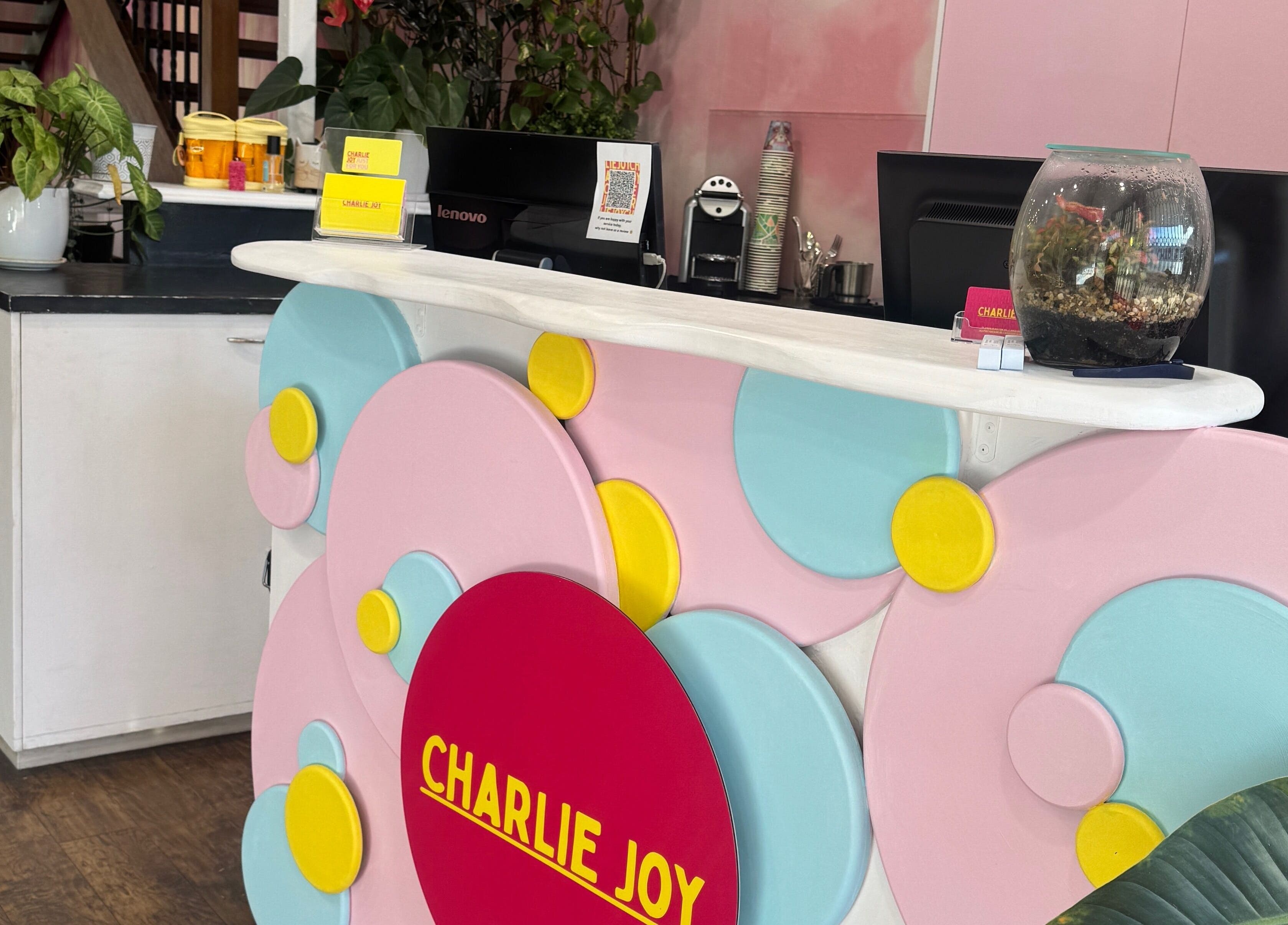 Reception area at Charlie Joy Salon in Caringbah, New South Wales, AU with colorful decor and lush plants.
