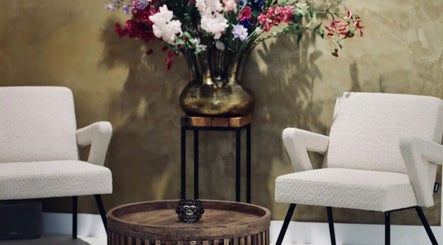 Cozy lounge with floral decor at Your Nail World, Haarlem, NL, featuring stylish pastel chairs.