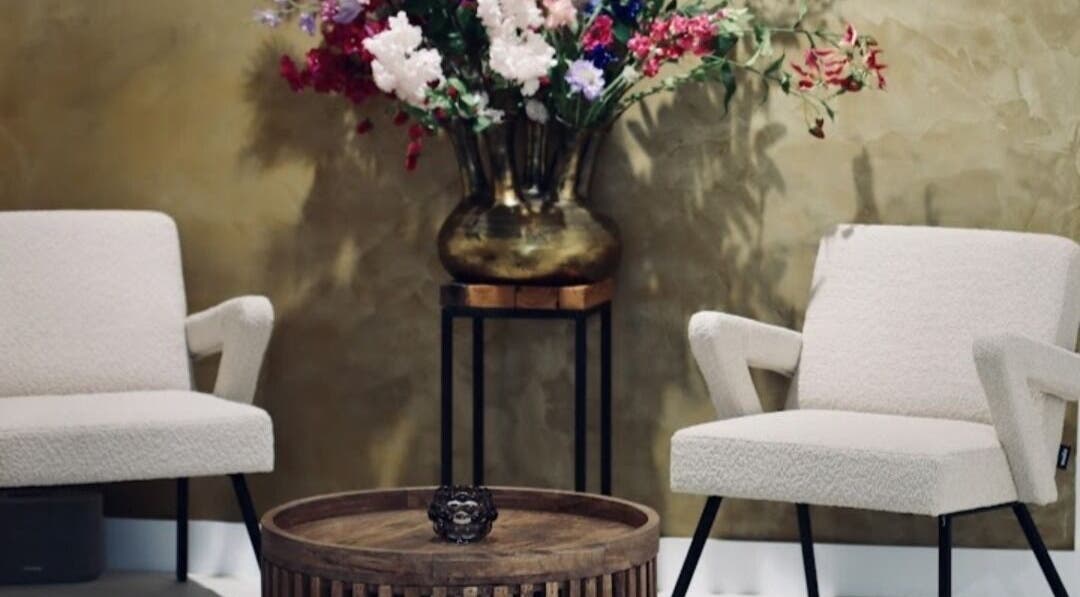 Cozy lounge with floral decor at Your Nail World, Haarlem, NL, featuring stylish pastel chairs.