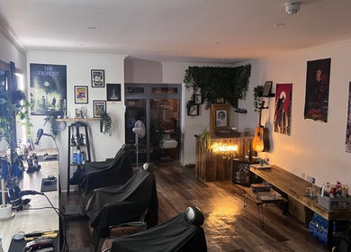Interior of Cult barbers featuring stylish decor in Coventry, England, GB with illuminated mirrors and rustic charm.