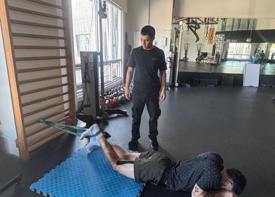 Persona entrenando con entrenador en PURAVIDATHERAPY, Escazú, CR, junto a equipo de gimnasio.