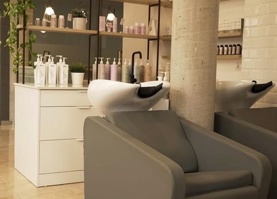 Zona de lavado en Espai I'M en Amposta, Catalunya, ES, con sillones modernos y productos de cuidado.