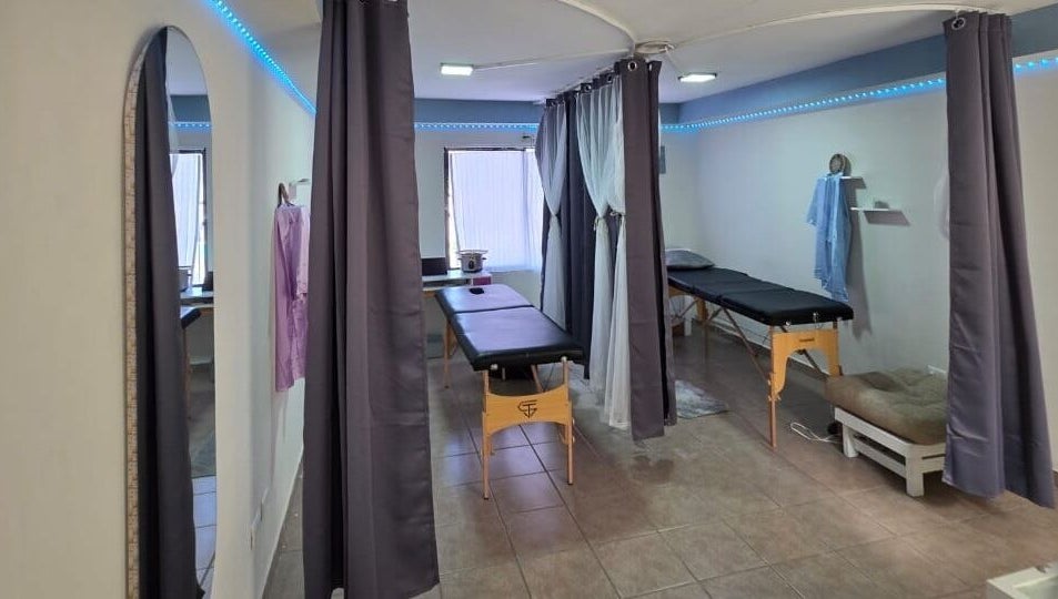 Área de masajes en Lume Lys, Durango, Durango, MX con cortinas azul y camillas cómodas.