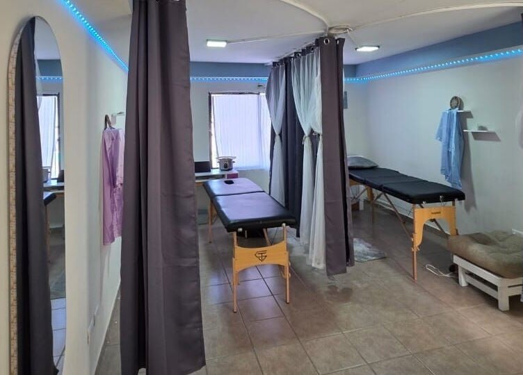 Área de masajes en Lume Lys, Durango, Durango, MX con cortinas azul y camillas cómodas.