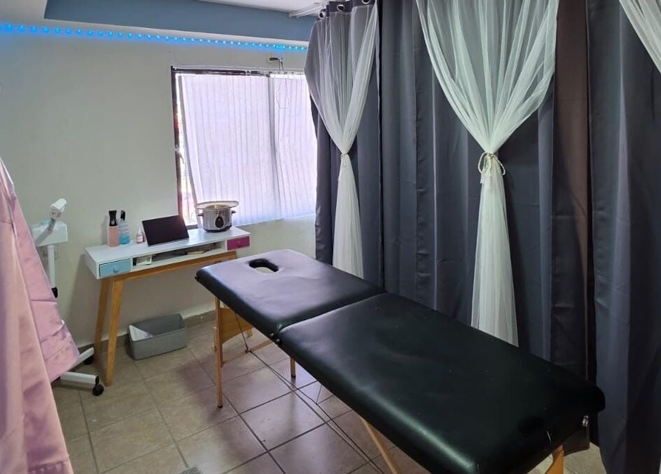 Sala de tratamientos en Lume Lys, Durango, Durango, MX, con camilla y cortinas elegantes.