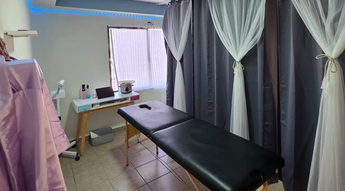 Sala de tratamientos en Lume Lys, Durango, Durango, MX, con camilla y cortinas elegantes.