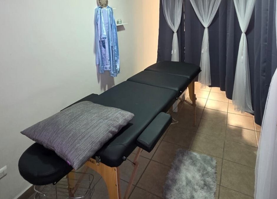 Sala de masajes en Lume Lys, Durango, Durango, MX, con camilla y cortinas elegantes para una experiencia relajante.