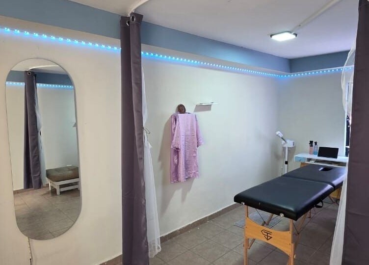 Sala de masaje en Lume Lys, Durango, Durango, MX, con cama negra y cortinas grises.